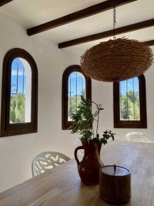 This villa in Benissa has a cozy dining room with many windows overlooking the greenery.