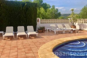 Holidayvilla Juntos with sunbeds on the terrace next to the swimmingpool.